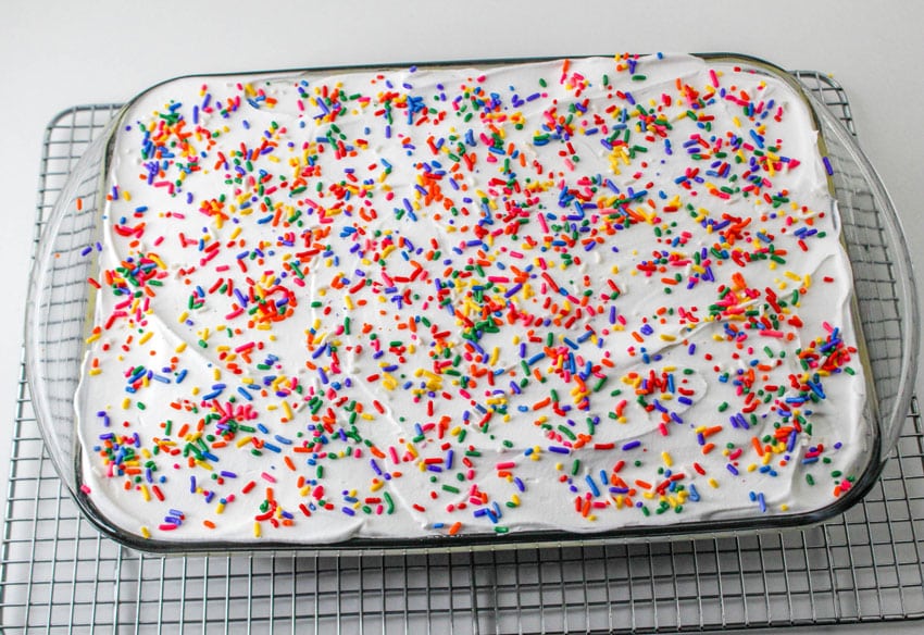 a layered funfetti lush dessert in a glass baking dish