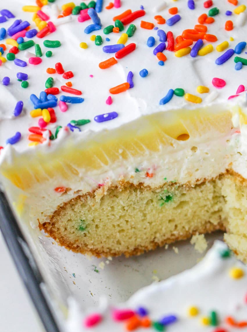 a layered funfetti dessert cake in a glass baking dish