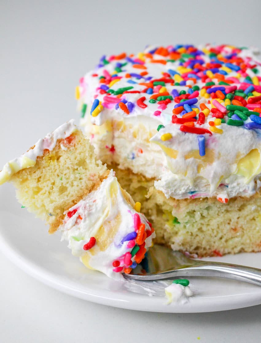 a slice of a layered funfetti cake dessert on a white plate