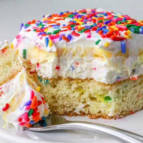 a slice of a layered funfetti cake dessert on a white plate