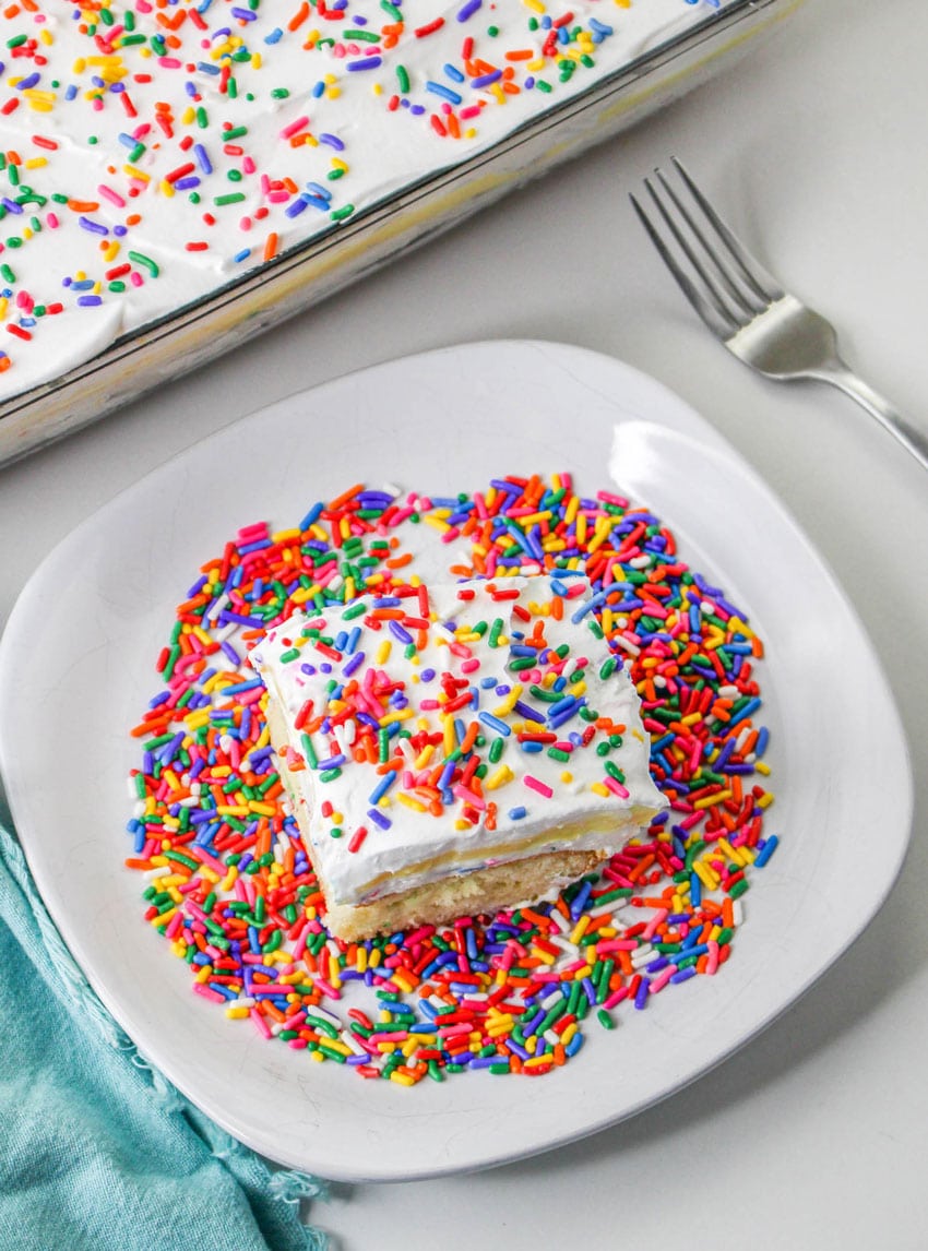 a slice of a layered funfetti cake dessert on a white plate