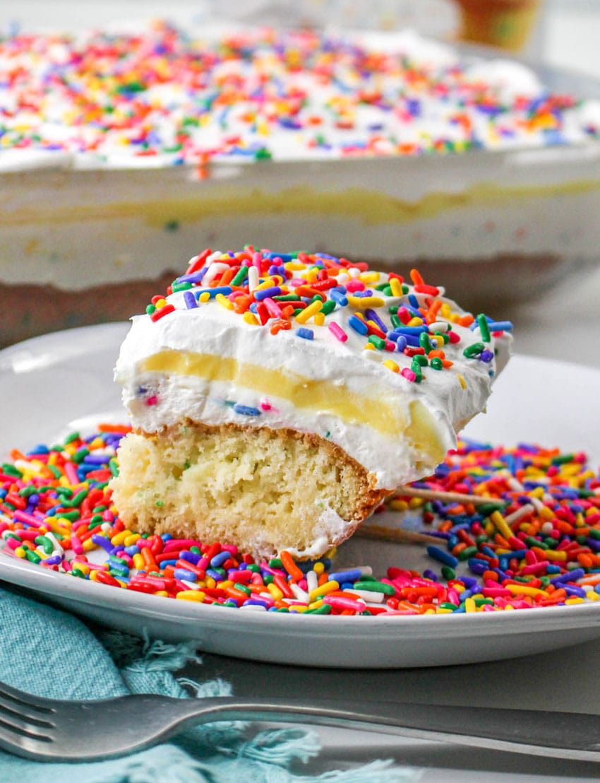 a slice of a layered funfetti cake dessert on a white plate