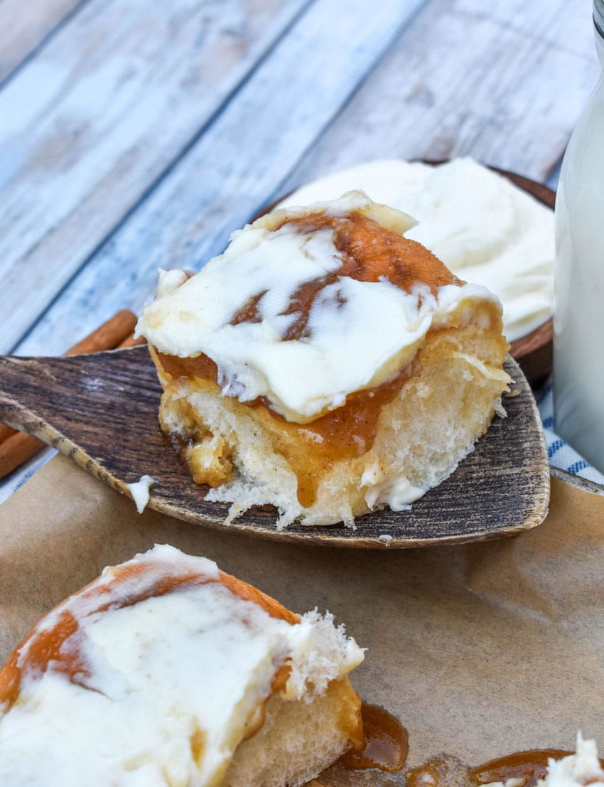 homemade cinnamon rolls made with hawaiian rolls on a parchment paper lined baking sheet
