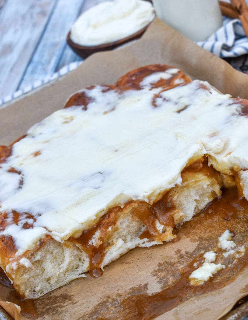 homemade cinnamon rolls made with hawaiian rolls on a parchment paper lined baking sheet