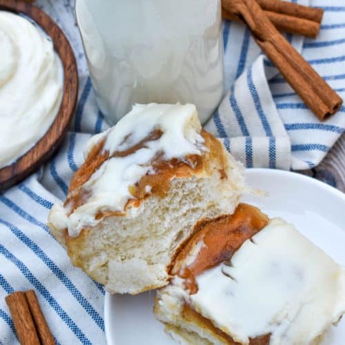 two hawaiian roll cinnamon buns stacked on a small white dessert plate