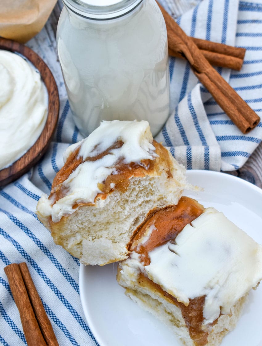 two hawaiian roll cinnamon buns stacked on a small white dessert plate