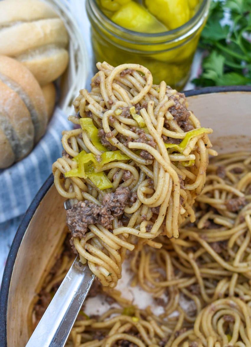 a silver spoon holding up a scoop of mississippi beef spaghetti