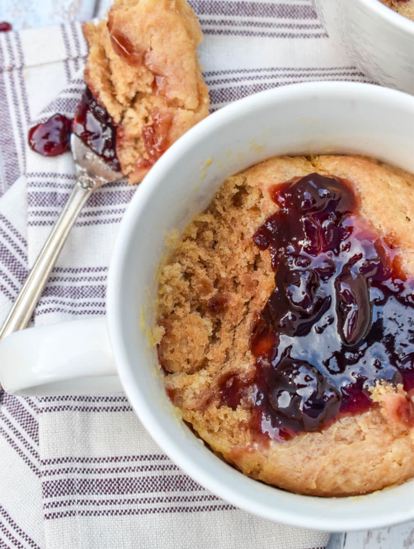peanut butter and jelly mug cakes in two white mugs