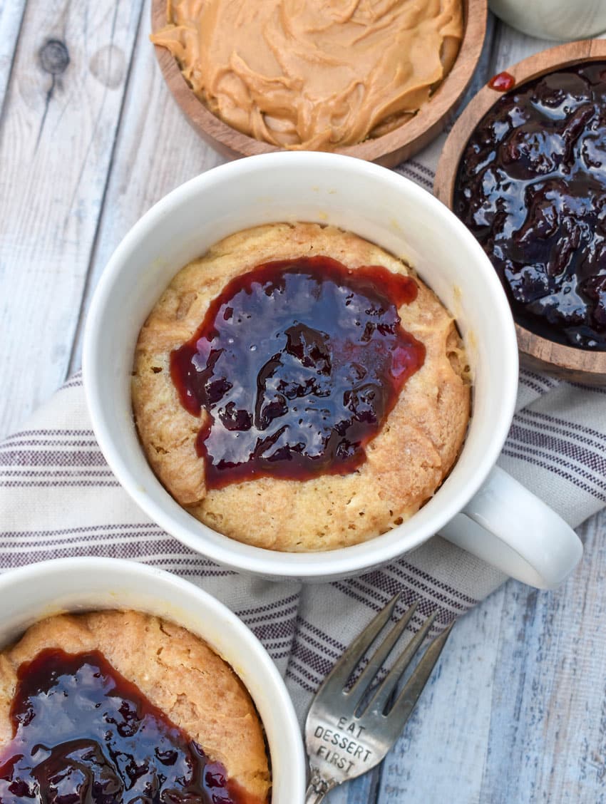 peanut butter and jelly mug cakes in two white mugs