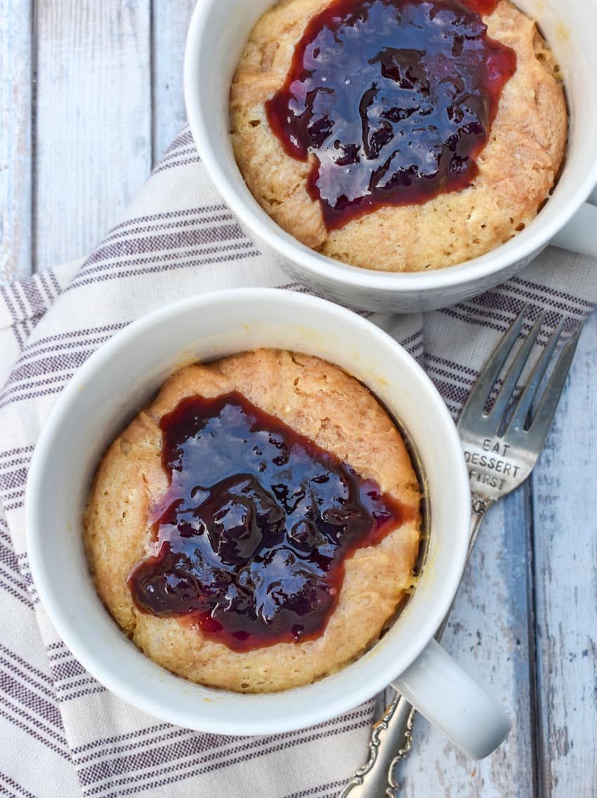 peanut butter and jelly mug cakes in two white mugs