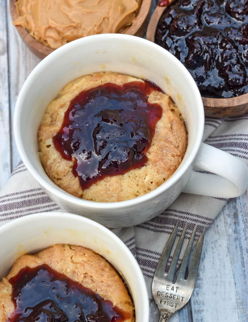 peanut butter and jelly mug cakes in two white mugs