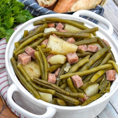 slow cooker green beans with ham in a white serving bowl