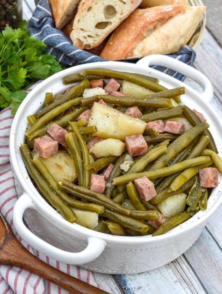 slow cooker green beans with ham in a white serving bowl