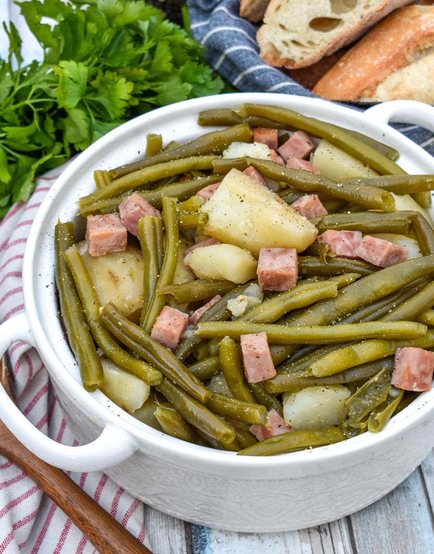 slow cooker green beans with ham in a white serving bowl