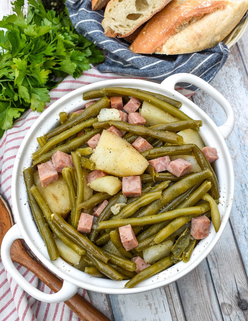 slow cooker green beans with ham in a white serving bowl