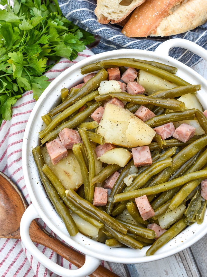 slow cooker green beans with ham in a white serving bowl