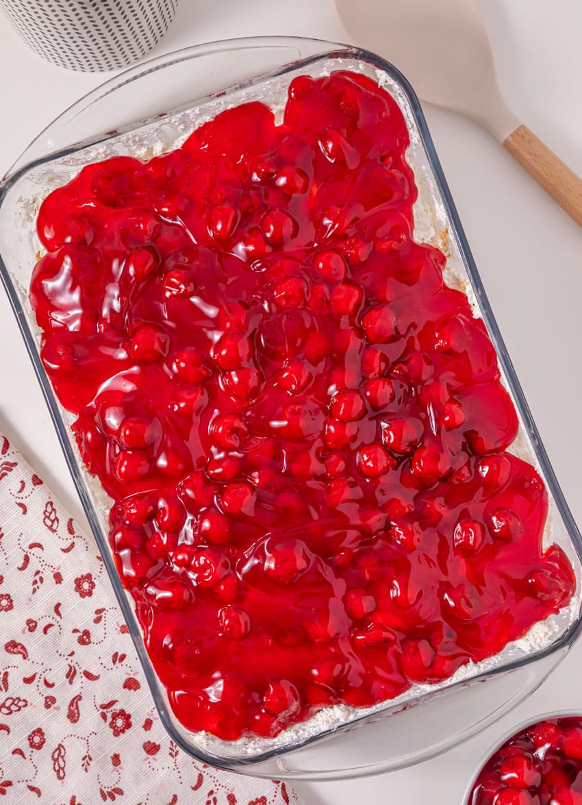 cherries in the snow layered dessert in a glass baking dish