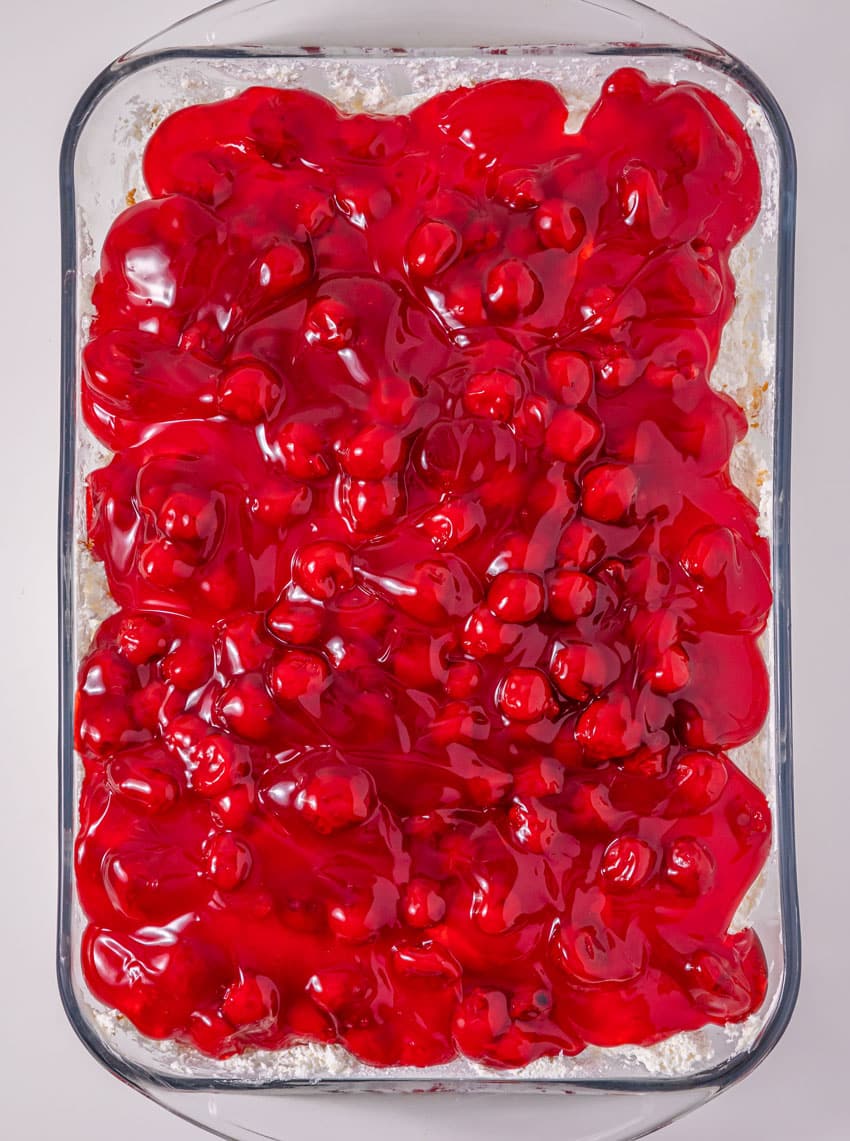 cherries in the snow layered dessert in a glass baking dish