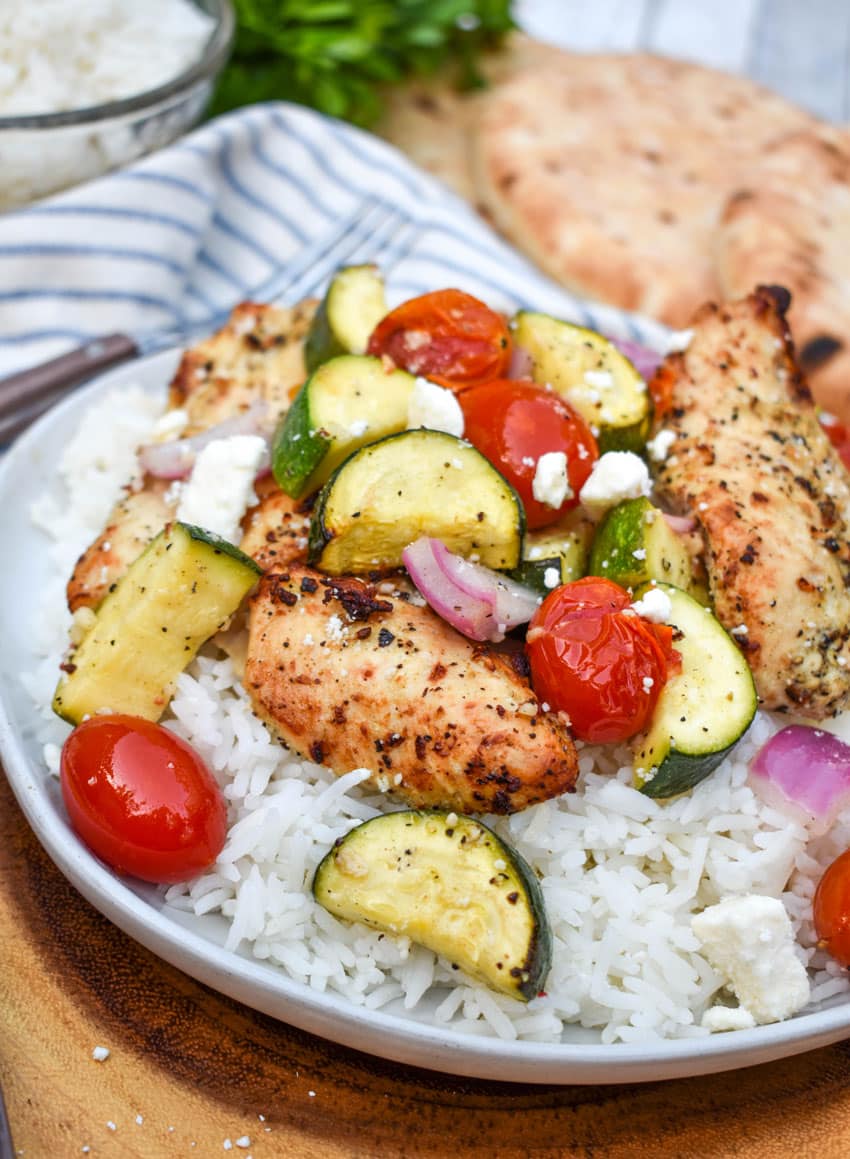 air fryer greek chicken and vegetables over steamed white rice on a white rice