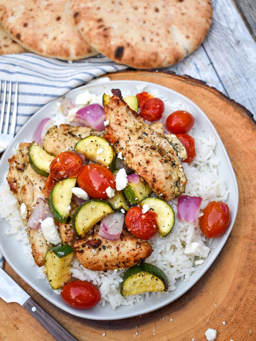 air fryer greek chicken and vegetables over steamed white rice on a white rice