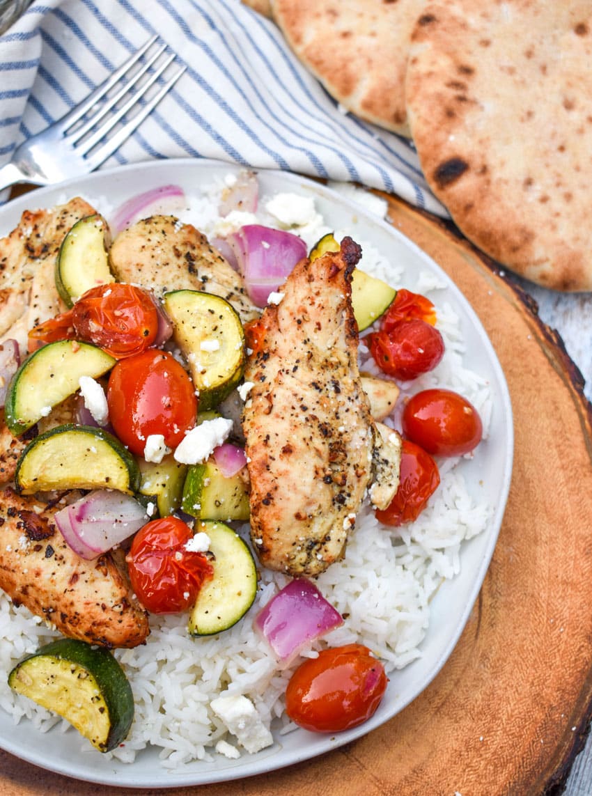 air fryer greek chicken and vegetables over steamed white rice on a white rice