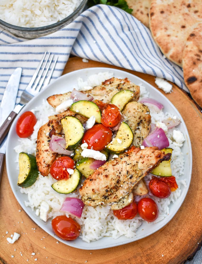 air fryer greek chicken and vegetables over steamed white rice on a white rice