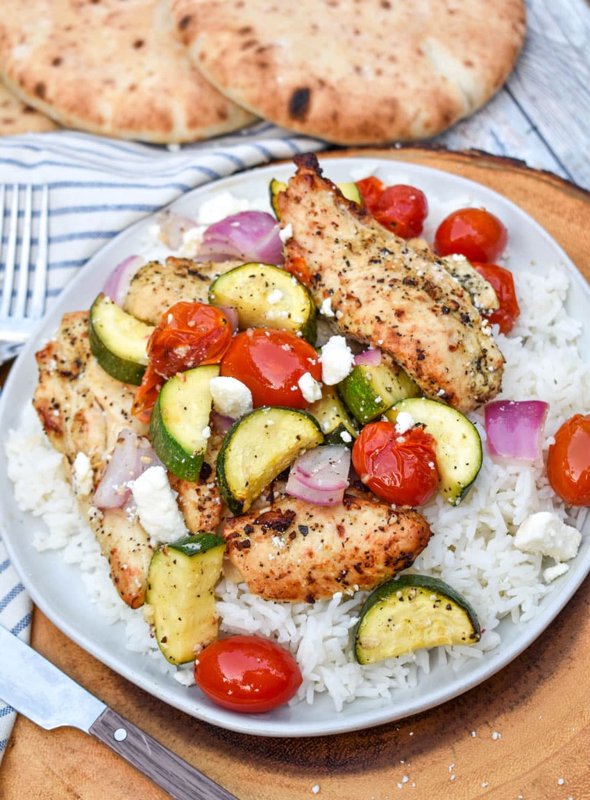 air fryer greek chicken and vegetables over steamed white rice on a white rice