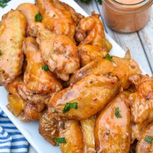 bang bang chicken wings piled high on a white serving platter