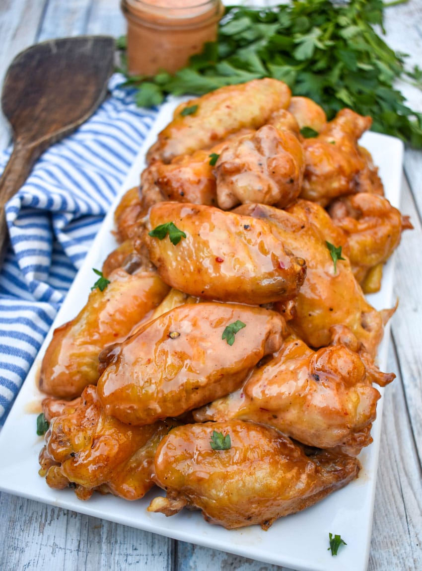 bang bang chicken wings piled high on a white serving platter