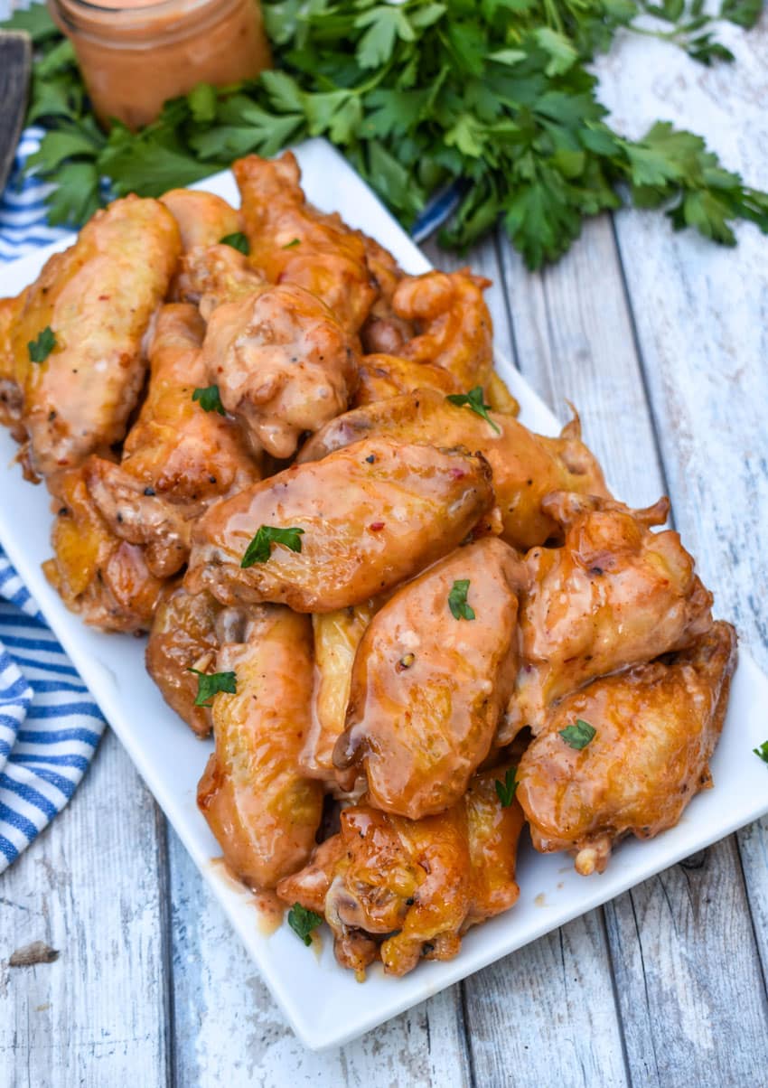 bang bang chicken wings piled high on a white serving platter