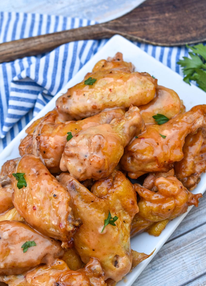 bang bang chicken wings piled high on a white serving platter