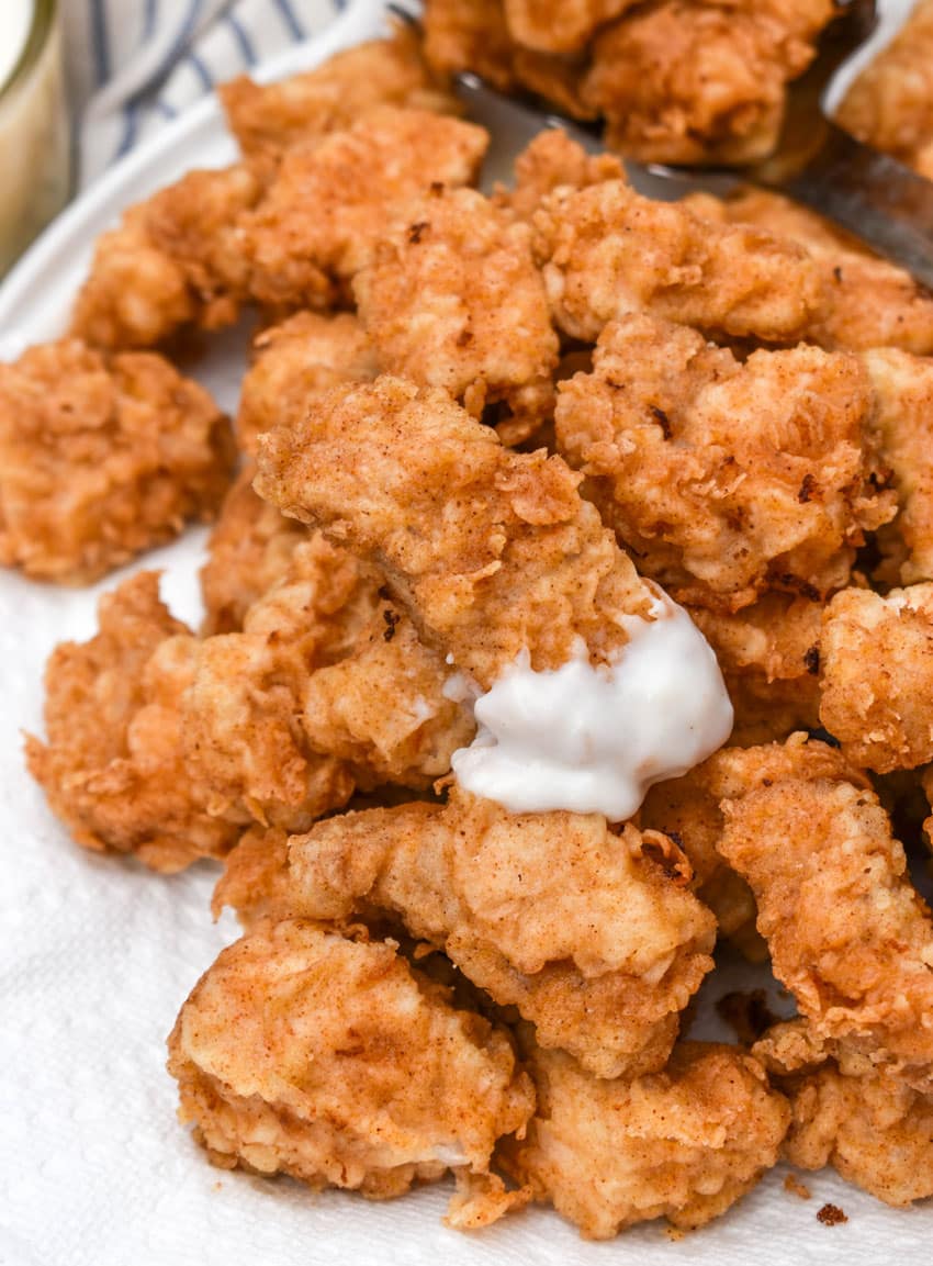 country fried pork nuggets draining on a paper towel lined plate
