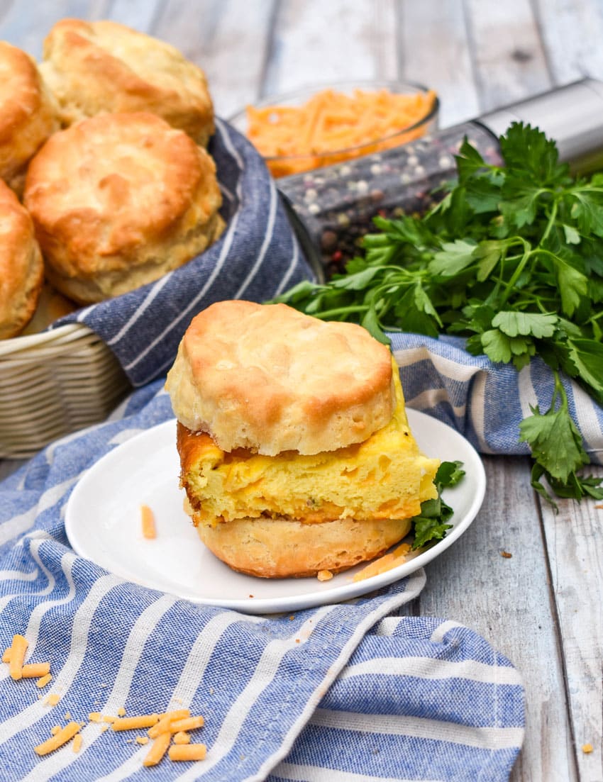 a slice of baked eggs on a biscuit on a small white plate
