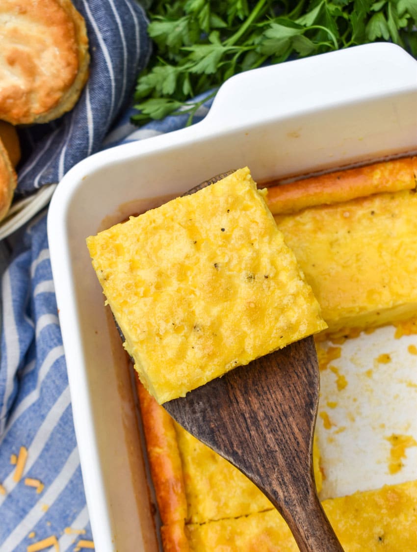 a wooden spatula holding up a slice of baked eggs