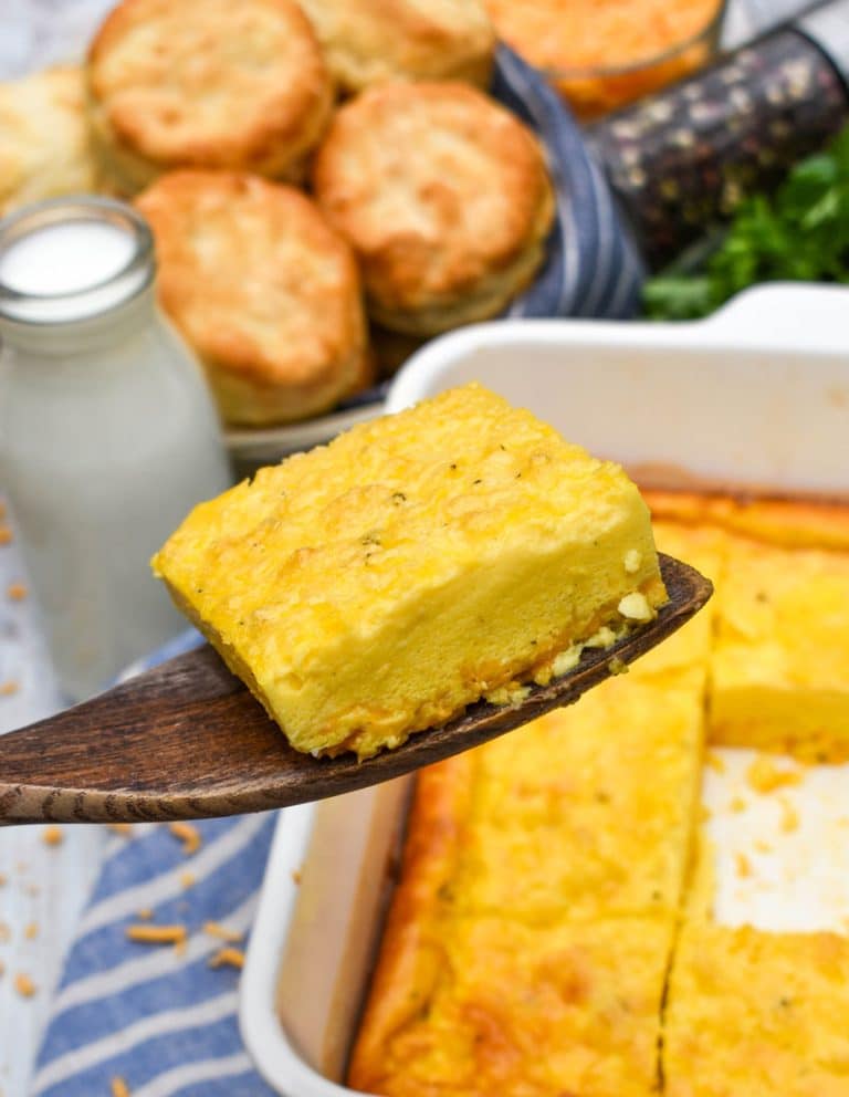 a wooden spatula holding up a slice of baked eggs