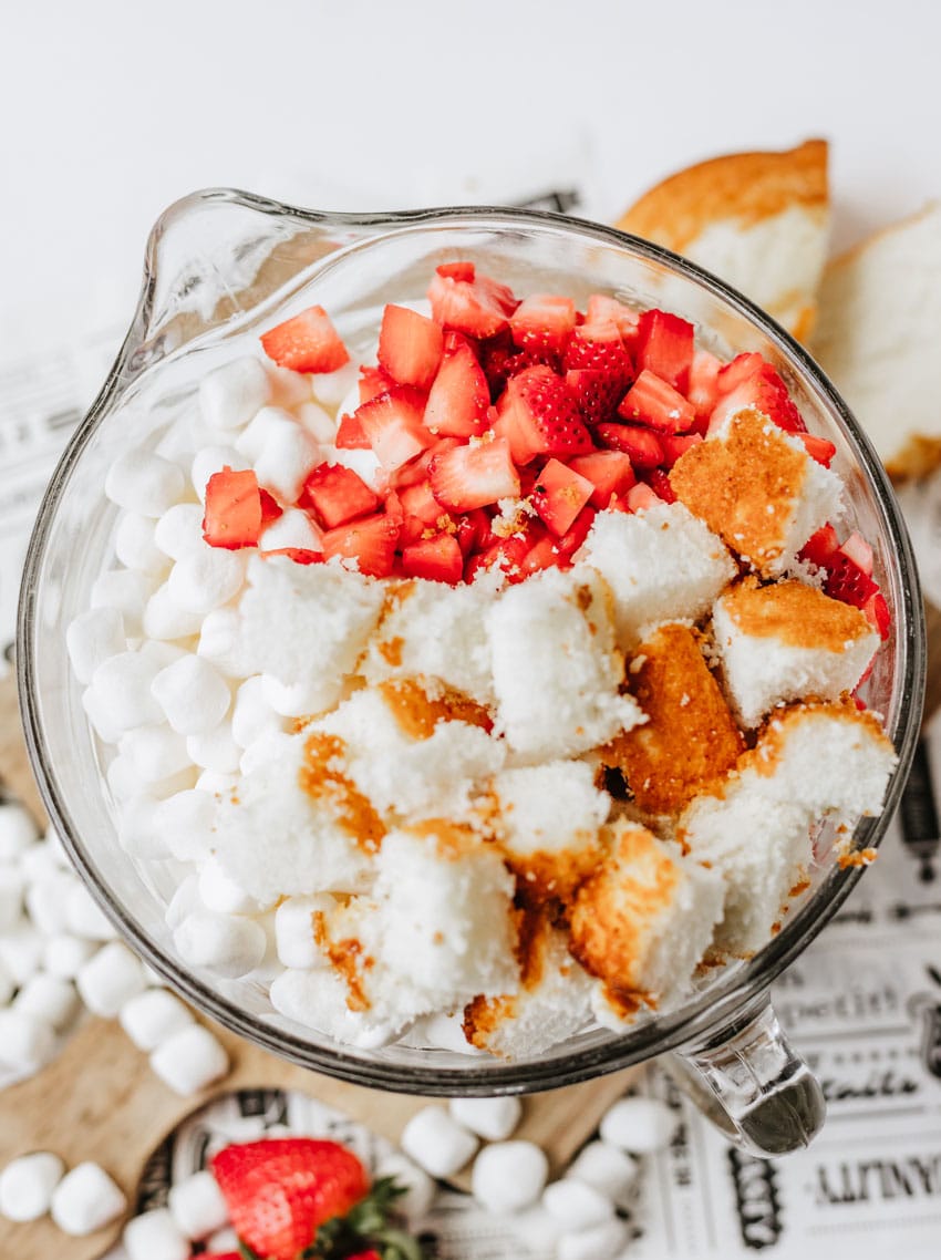 strawberry shortcake fluff salad ingredients in a glass mixing bowl