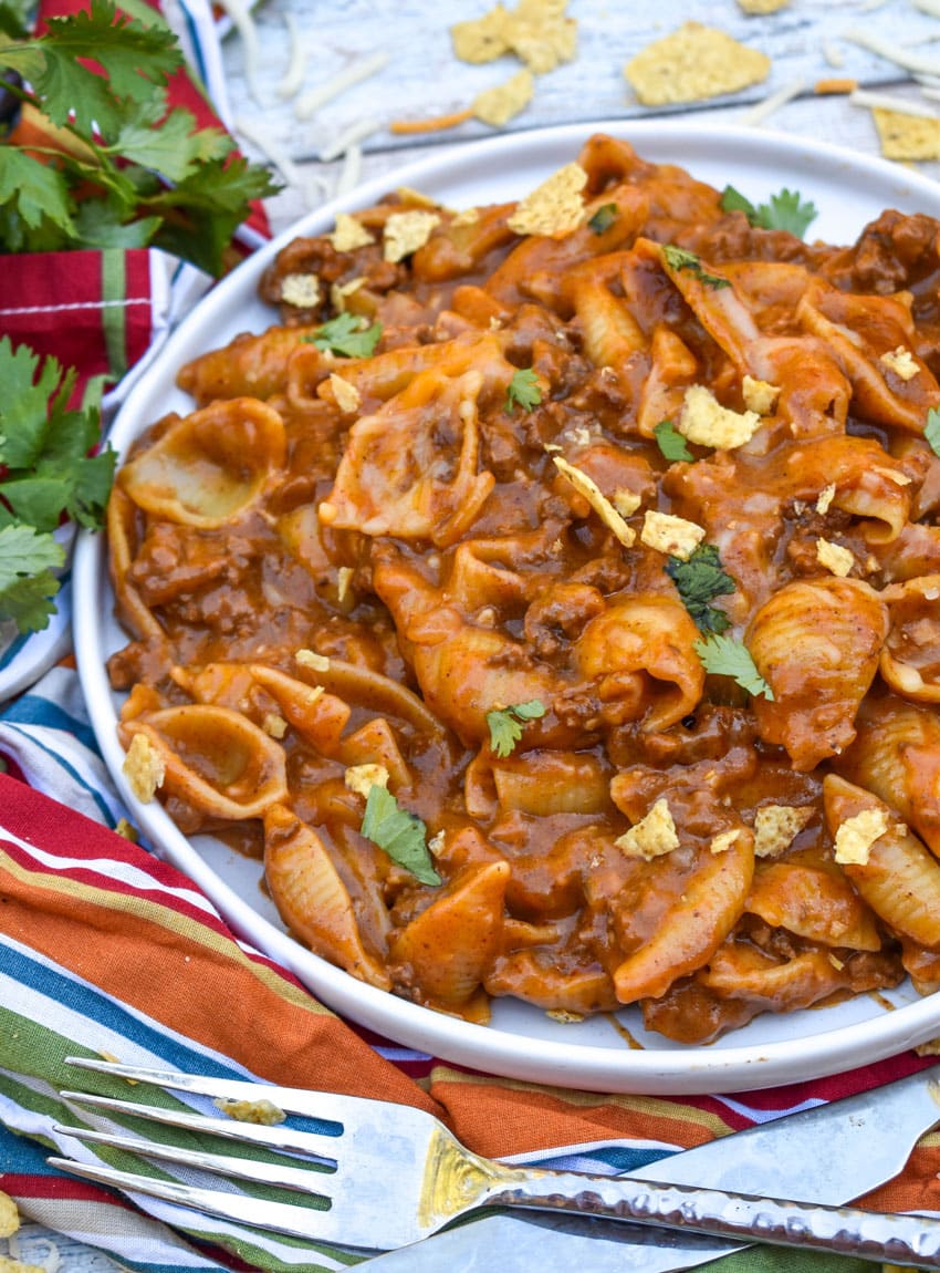 cheesy enchilada pasta on a white plate