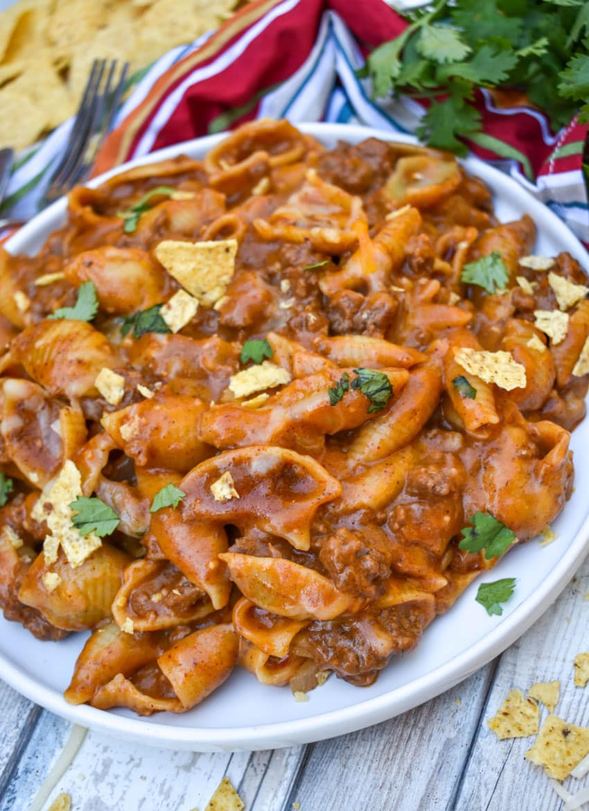cheesy enchilada pasta on a white plate
