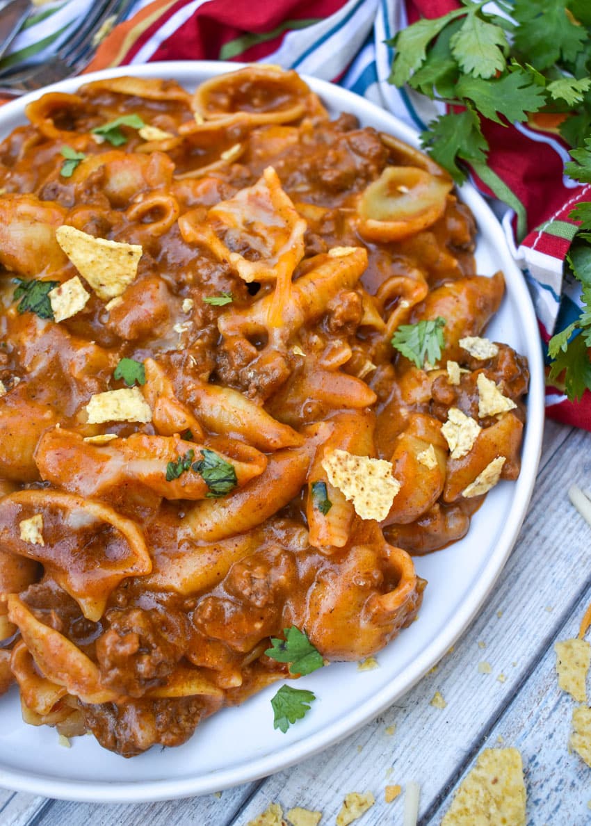 cheesy enchilada pasta on a white plate