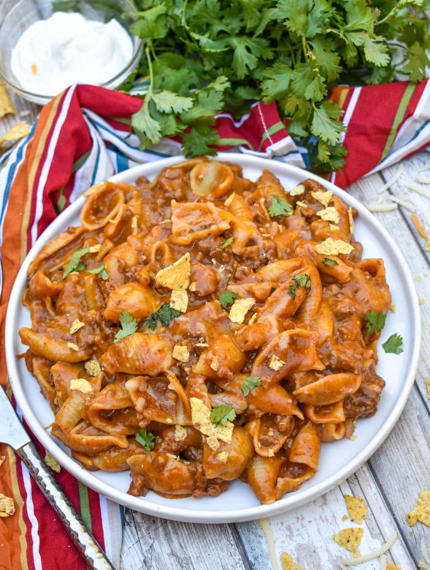 cheesy enchilada pasta on a white plate