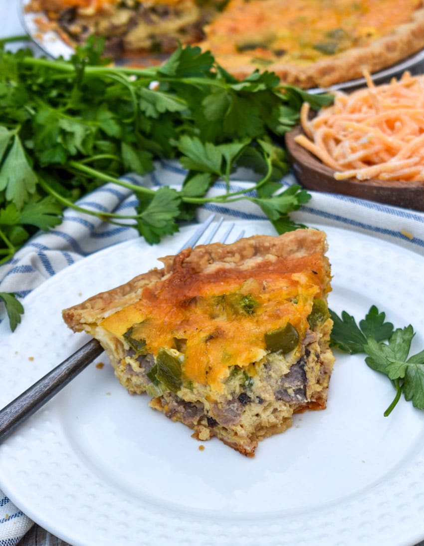 a slice of philly cheesesteak quiche on a white plate
