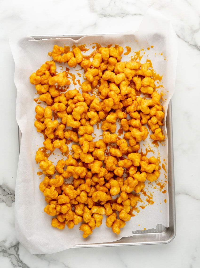 homemade bucee's beaver nuggets cooling on a parchment paper lined baking sheet