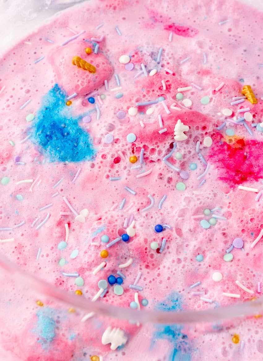 a close up of cotton candy punch topped with unicorn sprinkles