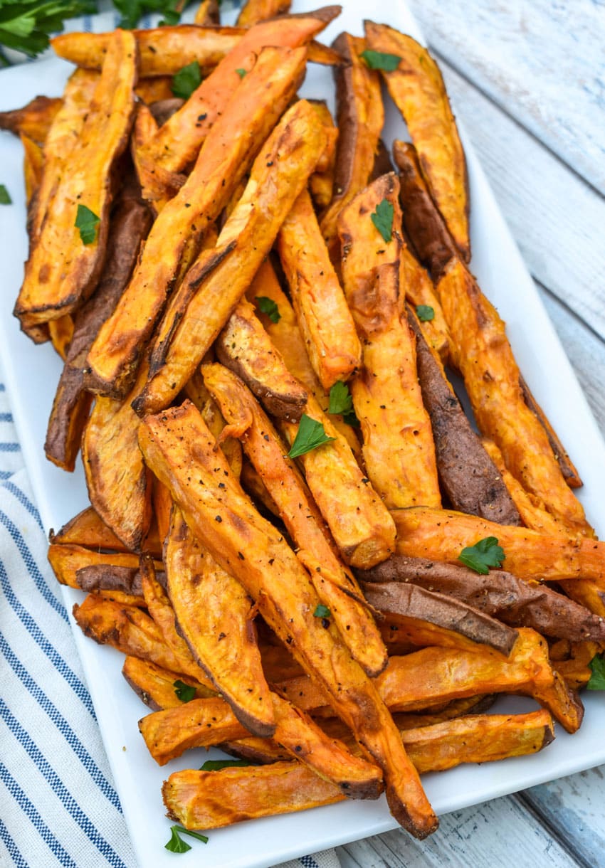 air fryer sweet potato fries piled on a white serving platter