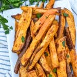 air fryer sweet potato fries piled on a white serving platter