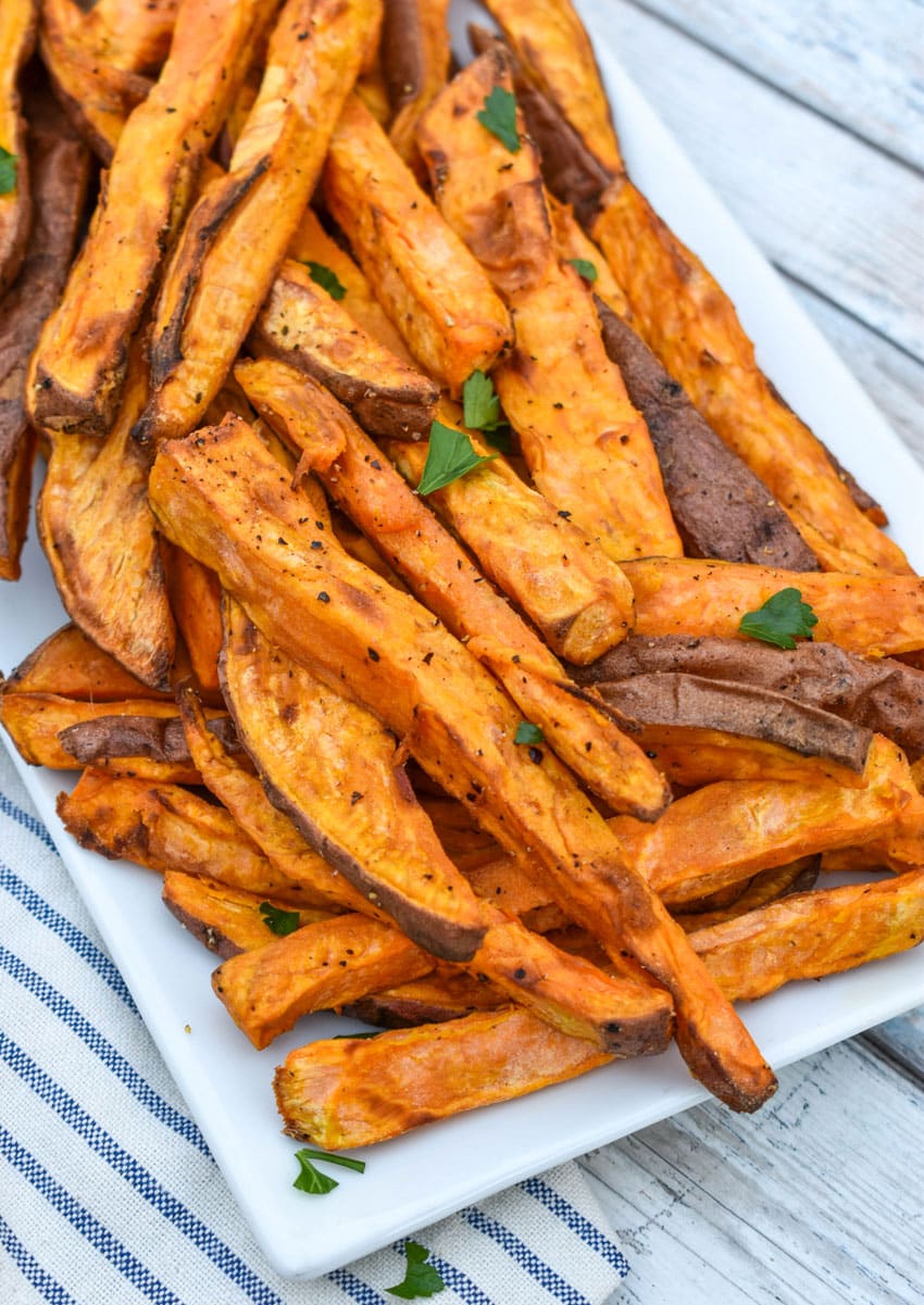 air fryer sweet potato fries piled on a white serving platter