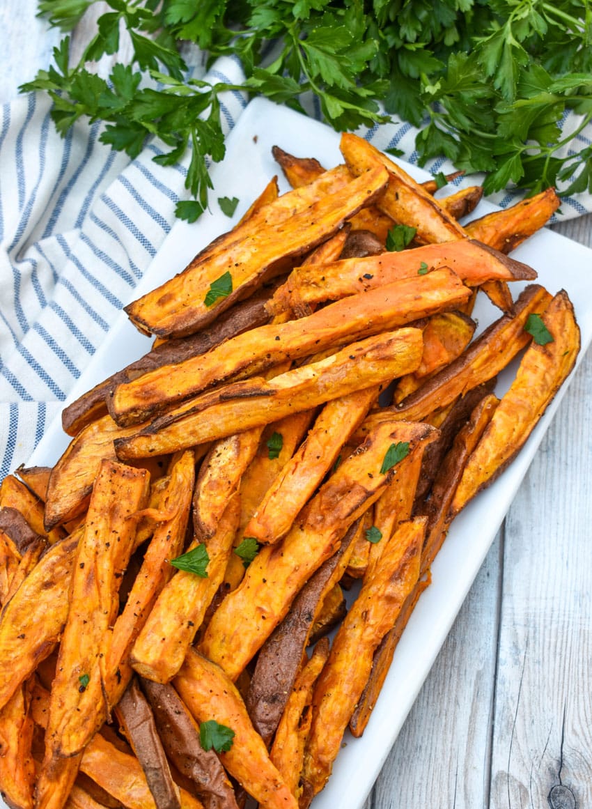 air fryer sweet potato fries piled on a white serving platter