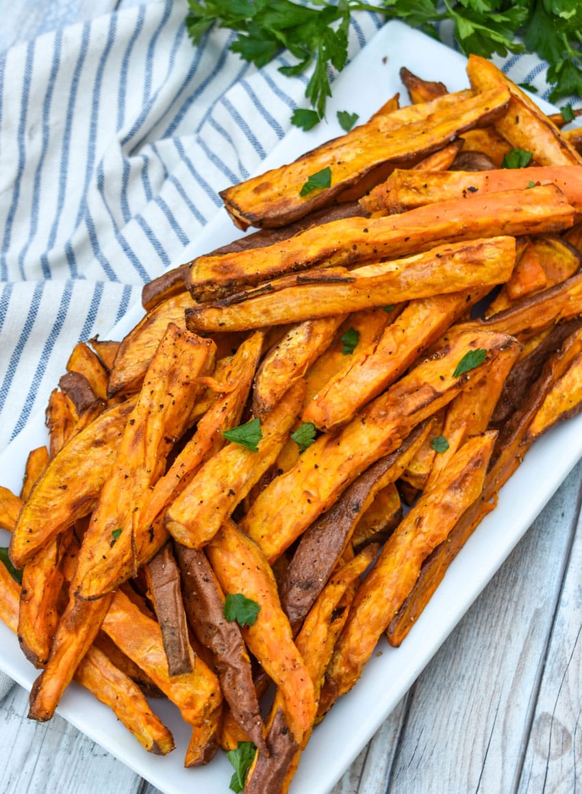 air fryer sweet potato fries piled on a white serving platter
