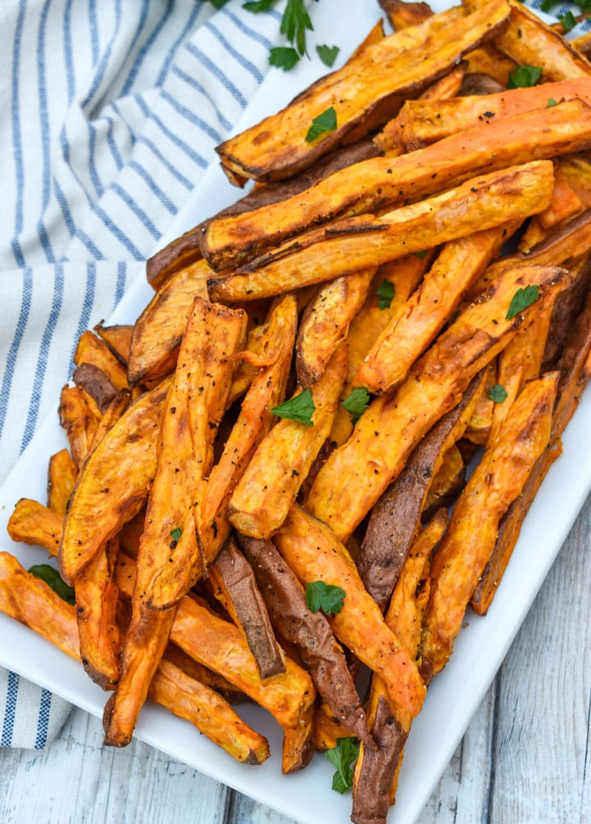 air fryer sweet potato fries piled on a white serving platter