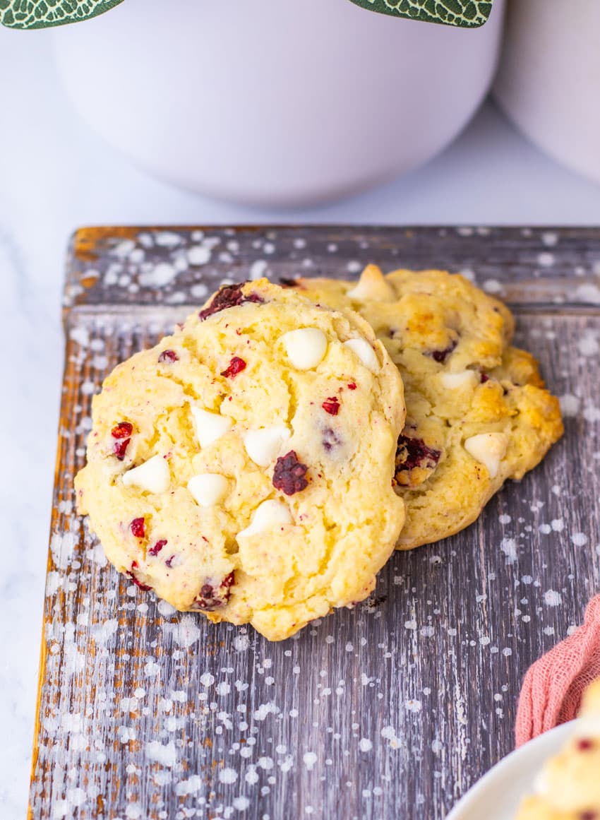 two copycat Subway raspberry cheesecake cookies on a wooden cutting board